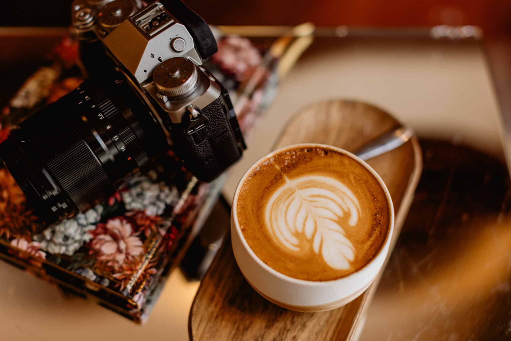 Appareil photo et café sur une table de travail